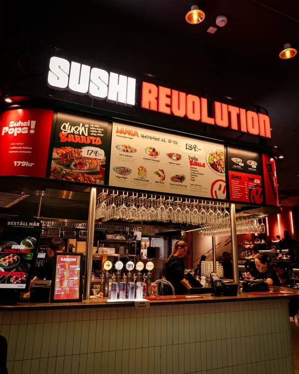 Kiosken i Mall of Scandinavia med lysande Sushi Revolution-skylt, menyskärmar och disk